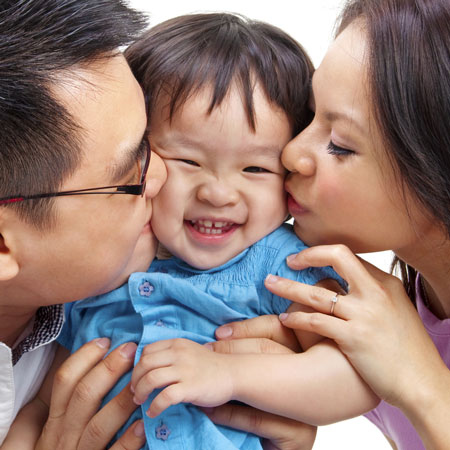parents kissing child after dental visit