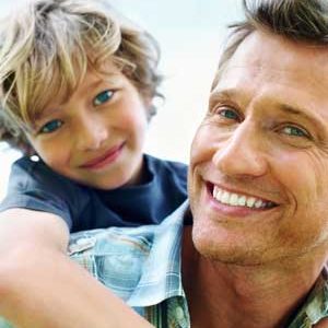 boy on fathers back smiling